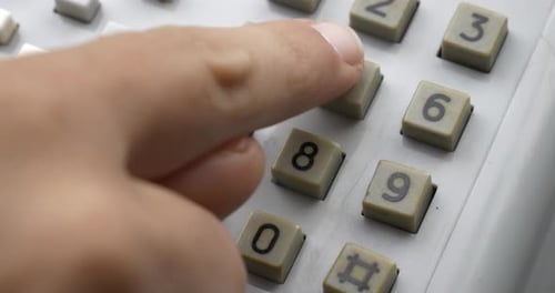Fingers Dialing a Number on an Old Landline Telephone