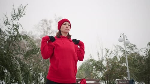 Woman Stretching in Snowy Park on Winter Day