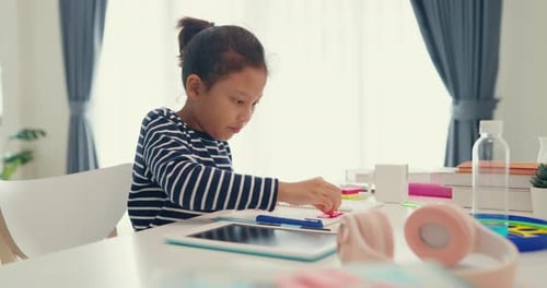 Asian girl with notepad use pencil focus on write notebook do homework from online.