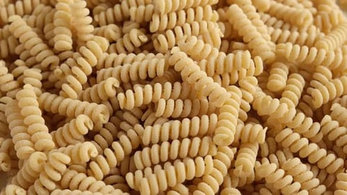Papel de parede de massa de fubá sem glúten em espiral macarrão cru de farinha de milho e arroz girando
