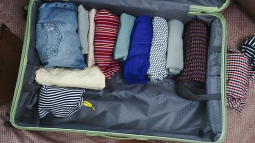 Clothes Being Packed Inside Suitcase Preparing For Trip