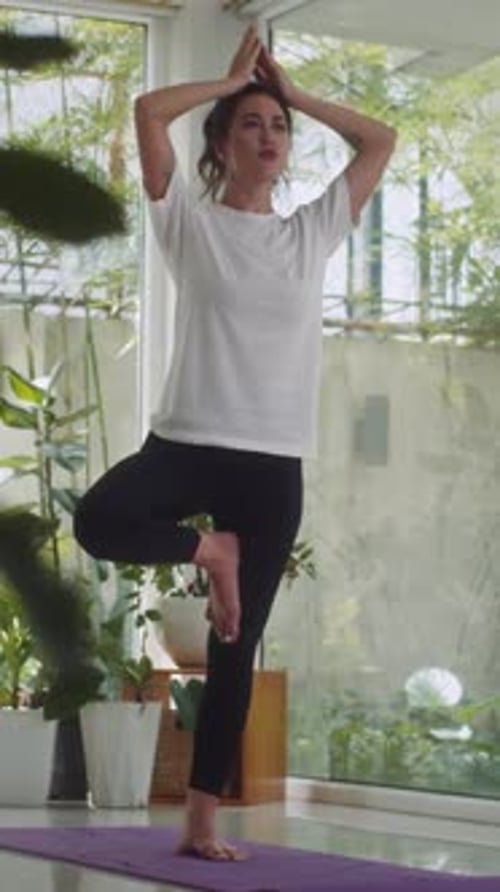 Young Woman Standing in Tree-pose at Yoga Class