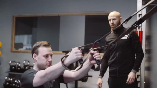 Personal Trainer mit Kunde im Suspensionstraining