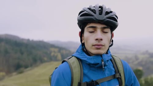 Young man with bicycle enjoying autumn nature in a foggy forest park
