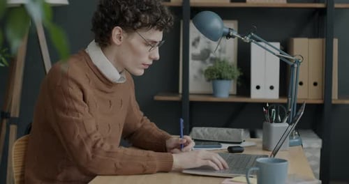 Portrait of Young Businessman Using Laptop Typing Working at Desk in Office