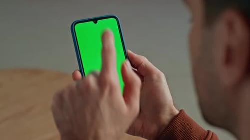 Man Hand Swiping Green Phone Screen Indoor Closeup Guy Holding Mockup Cellphone