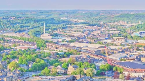 Wide drone shot over Huddersfield city centre with takeoff near Springwood industrial area