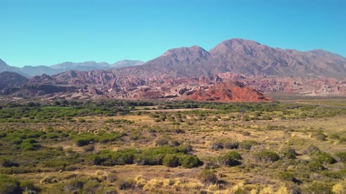 Aerial view drone flying over scenic red rocky mountains and green valleys