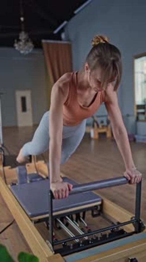 Woman Training Pilates on the Reformer Bed Reformer Pilates Studio Machine for Fitness Workouts in