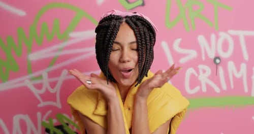 Excited Woman Gesturing in Front of Graffiti Wall