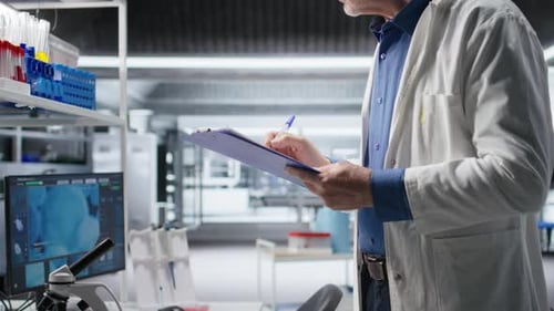 Scientist in Lab Coat Taking Notes in Laboratory