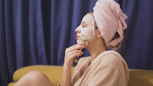 Woman Uses Facial Roller With Face Mask