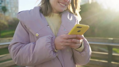 Smiling Woman Using Smartphone in the City