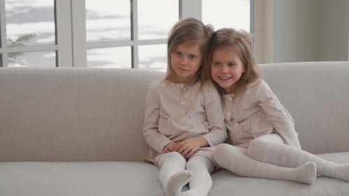 Two Little Girls Sitting Together on Couch