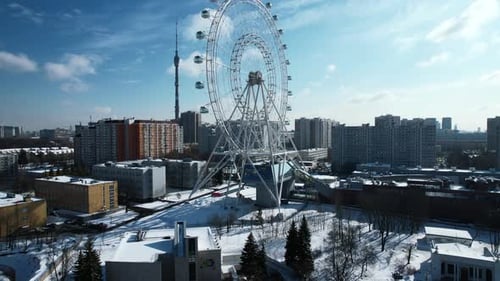 Top view of Ferris wheel in city center in winter. Creative. Large Ferris wheel stands in city