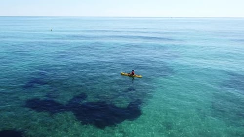 Kayak at the beach drone view. Kayaker trolling fishing from aerial view at Mediterranean sea