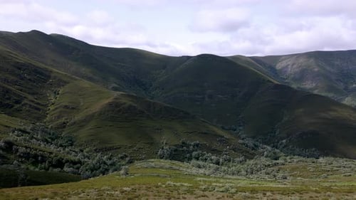 Aerial drone footage looking into a valley in a lush mountain range