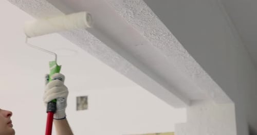 Man Painting Wall in White Color with Roller