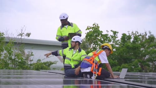 Gruppe eines jungen Ingenieurteams, das das Photovoltaik-Panelsystem instand hält.