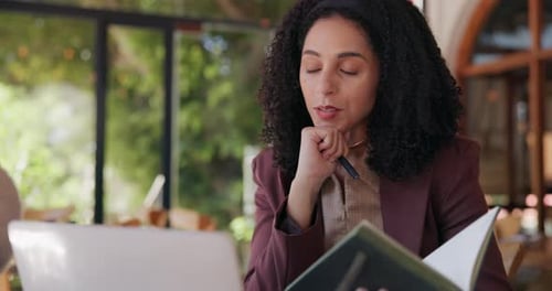 Business woman, laptop and video call with book in cafe for online meeting, discussion or chat