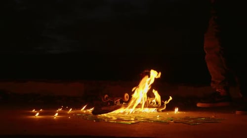 Flaming Skateboard on Ground at Night