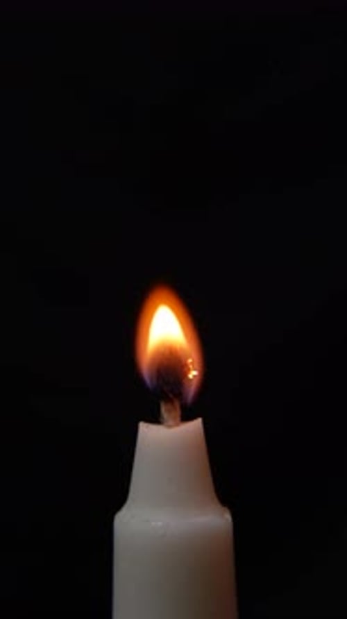 White Candle Flame Ignited in the Darkness