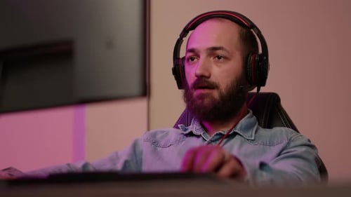 Man With Headphones Using Computer Indoors