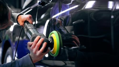 Closeup of the Hands of a Car Mechanic at a Service Station Doing the Final Polishing to Shine