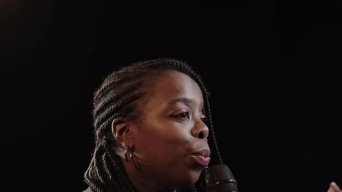 Smiling Woman Speaking into Microphone at Event