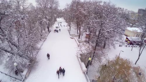 Winter City Park mit Schnee und Drohnenantenne für wandelnde Menschen