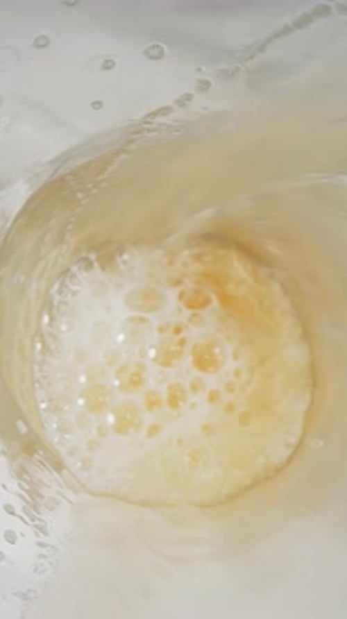 Cerveza dorada natural con mucha espuma en taza de vidrio Macro