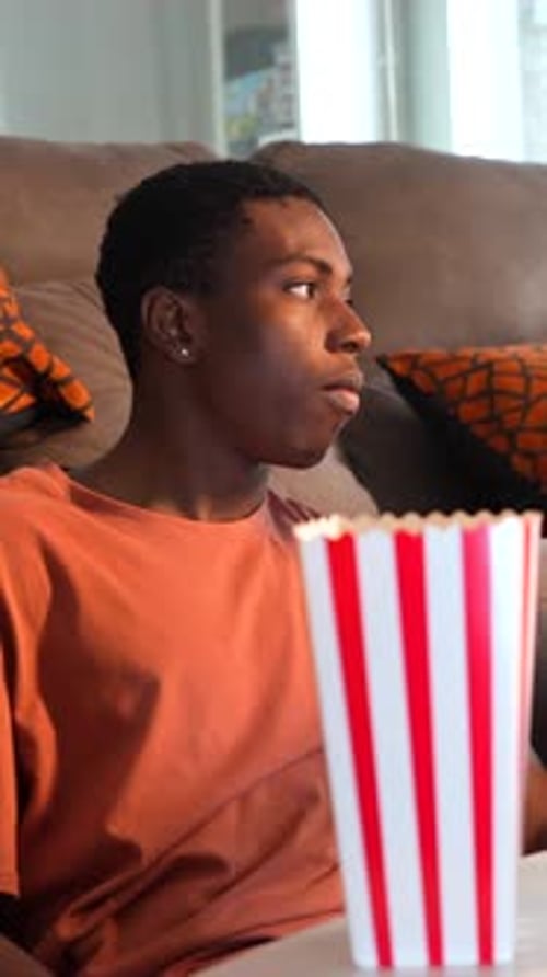 Young couple watching movie and eating popcorn