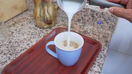 Milk Poured Into a Blue Mug and Stirred