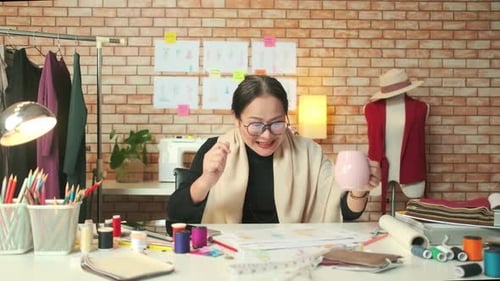 Asiatische Modedesignerin arbeitet nach Ideen und zeichnet Skizzen für ein Kleidungsdesign.