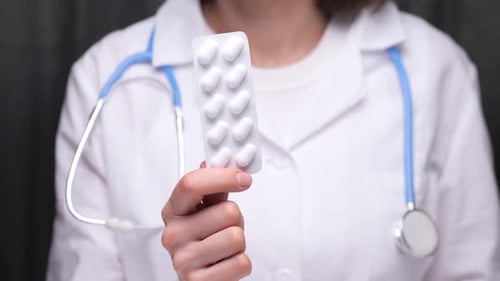 Doctor Holds Blister Pack of White Pills