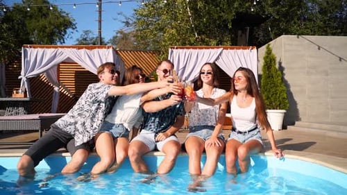 Friends Celebrating Poolside with Drinks on Sunny Day