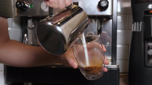 Pouring Milk into Espresso Glass Close Up