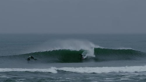 Dos surfistas surfeando juntos una poderosa ola marina