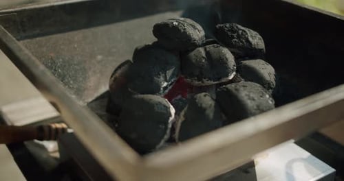Charcoal glows on a grill.