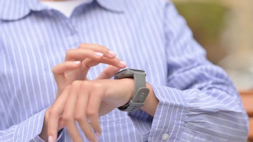 Close up of Hispanic Woman Browsing Internet Smart Watch Outdoor