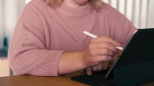 Unrecognizable Woman Hand Using a Graphic Tablet Computer with Stylus Pencil Pen in a Cafe Cropped