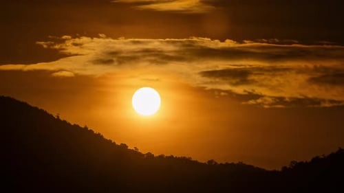 Timelapse of dramatic sunrise with orange sky in a sunny day.