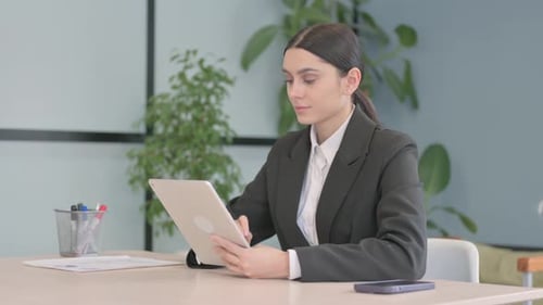 Woman Using Digital Tablet at Office Desk