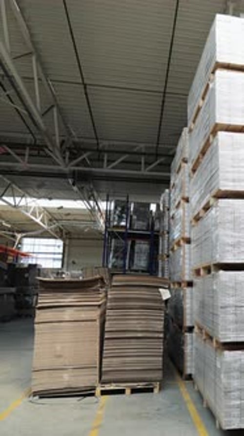 packed pallets of a parquet board stand in the warehouse at a woodworking plant.
