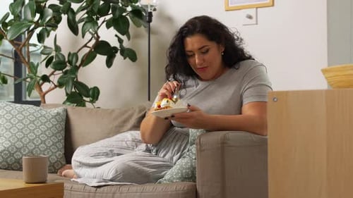 Woman Enjoying Delicious Cake on Cozy Couch