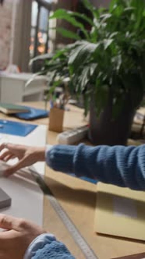 Three Multiethnic Architects Discussing Blueprints at Office Table