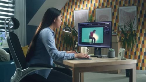 Woman Editing Video on Computer in Home Office