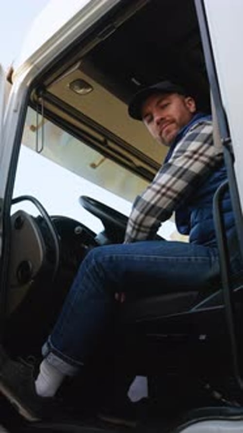 Truck Driver Sitting in Cabin and Looking Outside