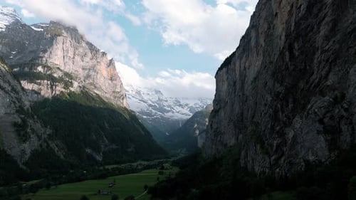 Flying throught the valley and alp mountains of Grindelwald Switzerland towards the snowy glaciers