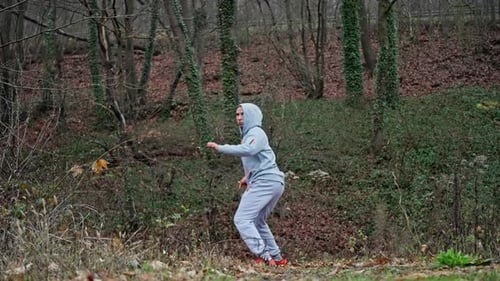 Man Practicing High Kicks in a Forest